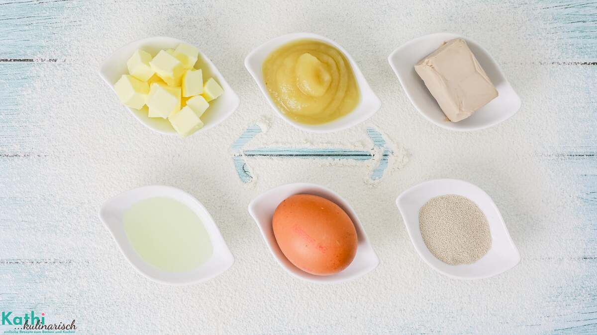 Ersatzzutaten-Rechner Beitragsbild: Zu sehen sind 6 Schälchen. Links eine Schale mit Butterwürfeln und darunter eine mit Öl. In der Mitte eine Schale mit Apfelmus und darunter ein Ei. Rechts eine Schale mit einem Würfel Hefe und darunter eine mit Trockenhefe. Die Zutaten sind so gegenüber gestellt, wie sie auch ersetzt werden können.