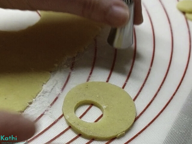 Mit Hilfe einer Tülle bei jedem zweiten Keks ein weiteres Loch ausstechen.