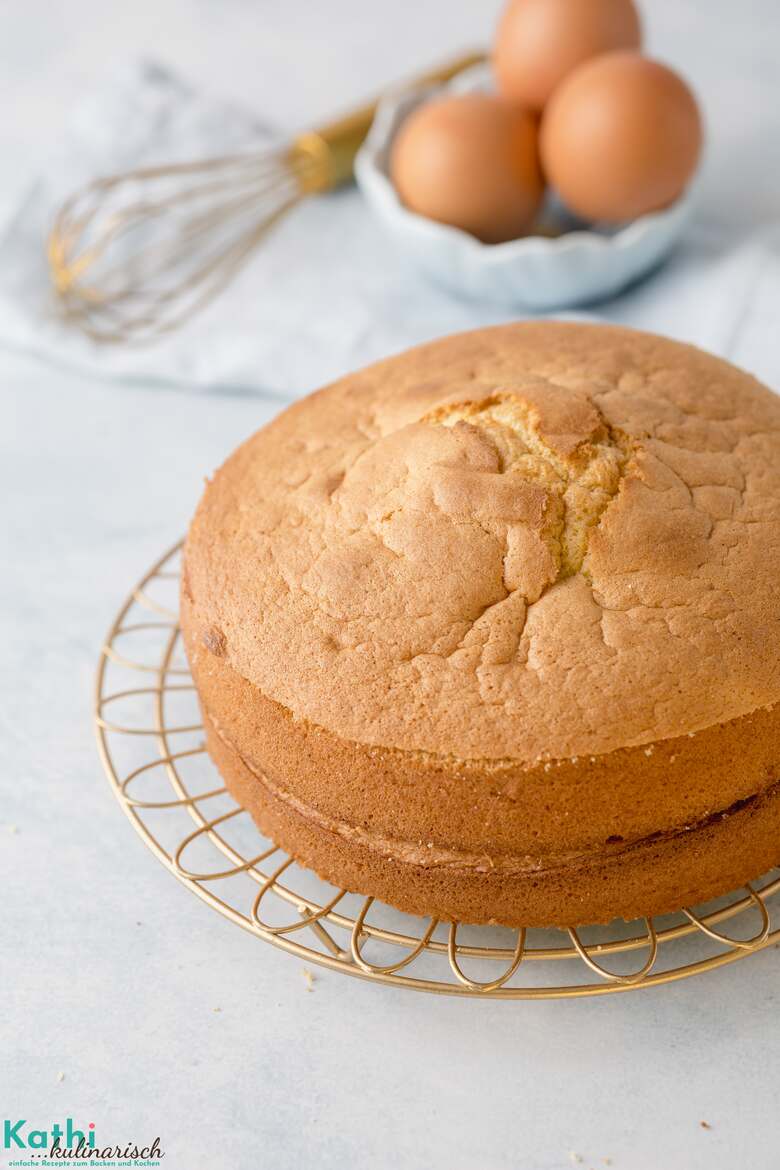 Dieses Biskuit Grundrezept eignet sich nicht nur für Rouladen, sondern auch für Tortenböden und Kuchen, wie hier zu sehen. Dieser steht auf einem goldenen Abkühlgitter. 